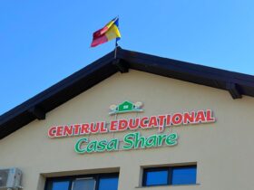 Fațada Centrului Educațional Casa Share, cu numele centrului pe clădire și steagul României pe acoperiș